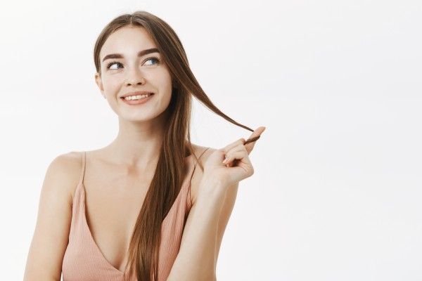 Menina feliz após passar por tratamento profissional de hidratação dos cabelos 
