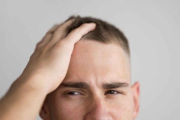 Homem penteia o cabelo com os dedos