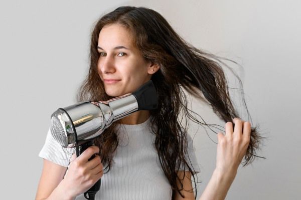 Mulher usando secador de cabelo