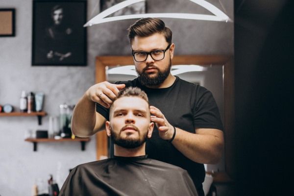 Cabalereiro penteando o cliente
