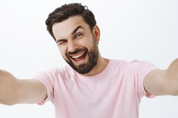 Homem barbudo expressivo de camiseta rosa