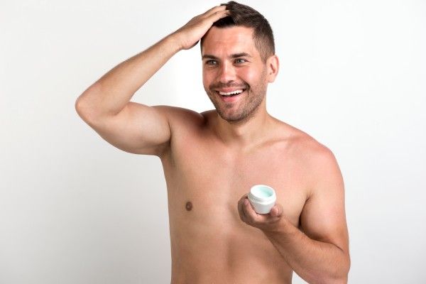homem aplicando produto no cabelo