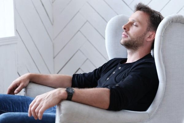 homem sentado no sofá, muito relaxado