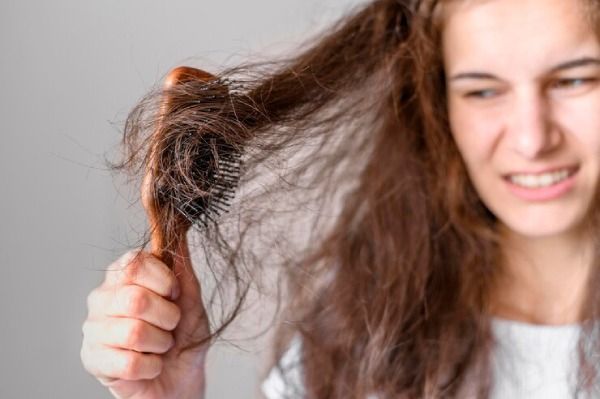mulher lutando para escovar o cabelo