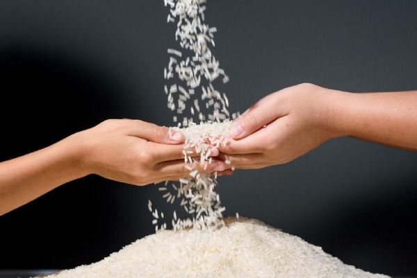 Mão com arroz - água de arroz para cabelos