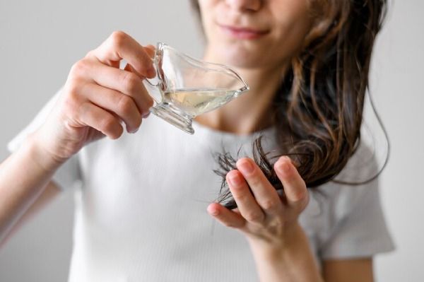 Mulher aplica azeite de oliva no cabelo
