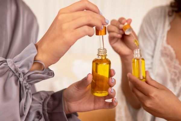 Mãos segurando recipientes de azeite de oliva para o cabelo