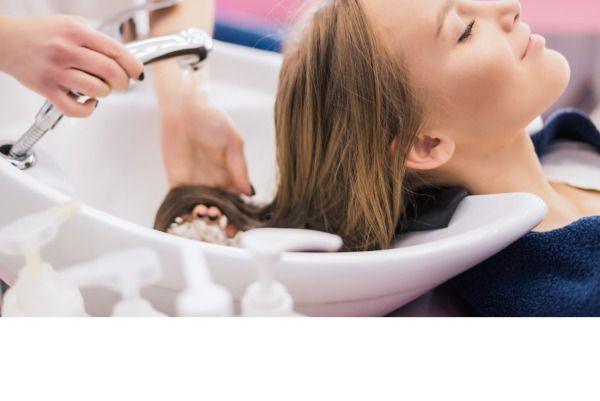 Menina do barbeiro, penteando o cabelo no salão de beleza. bela dama com o cabelo lavado por cabeleireiro em salão de cabeleireiro.