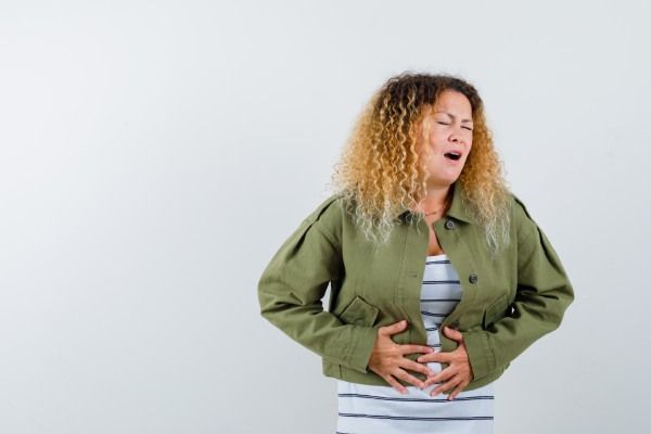 Mulher com dor de estômago - Tricofagia