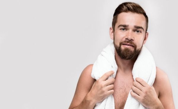 Homem se cobrindo com uma toalha branca com espaço de cópia