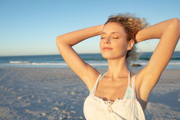 o sol danifica o cabelo - Mulher na praia não sabe que o sol danifica o cabelo