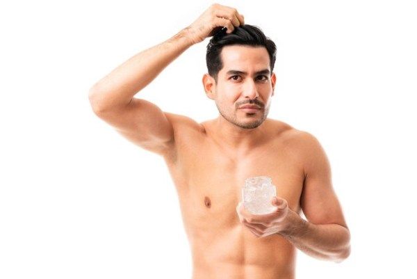 posso usar gel após o transplante capilar - Bonito jovem modelo masculino aplicando gel de estilo em seu cabelo no fundo branco