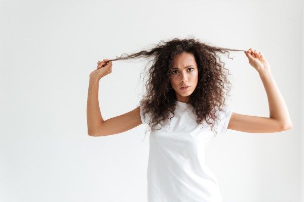 Mulher tocando seu cabelo resseco