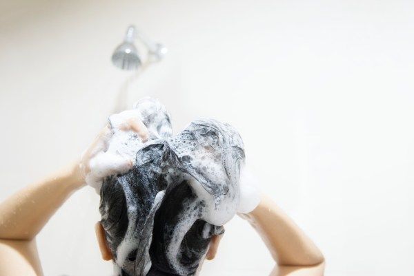 Senhora usando xampu para lavar seu cabelo 