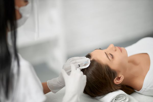 Mulher é preparada para um transplante capilar feminino