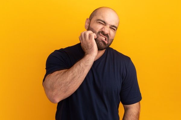 Homem com cárie e calvície 