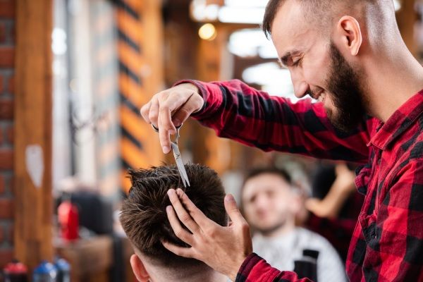 Barbeiro usando uma tesoura para fazer um penteado