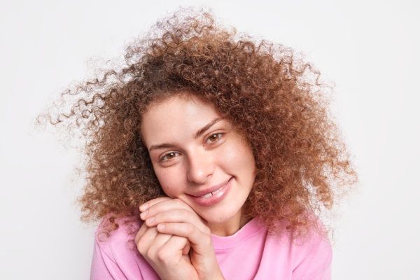 Bela jovem com finos cachos procura saber como melhorar a densidade do cabelo cacheado