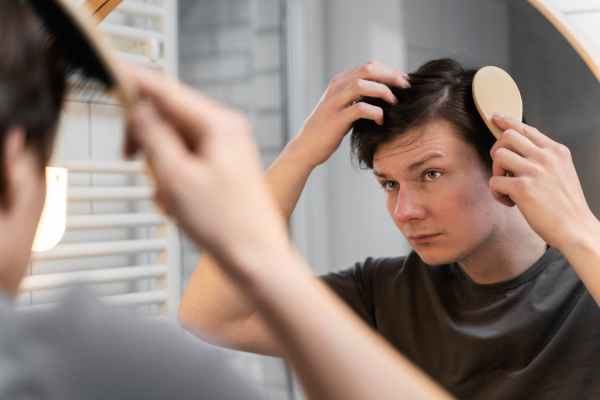 Homem vendo os resultados do Minoxidil em seu cabelo 