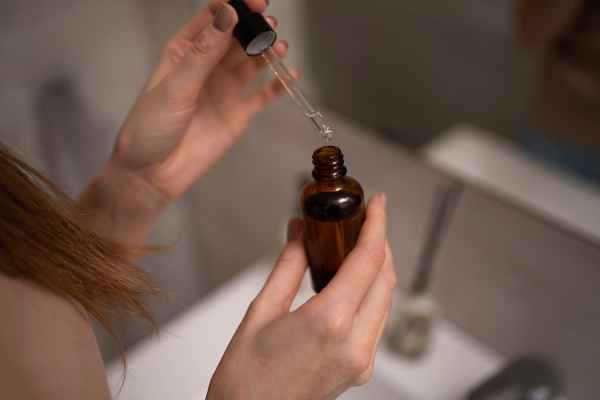 Mulher com frasco de Minoxidil