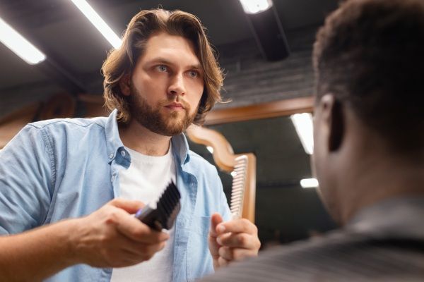 Homem de vista lateral cortando o cabelo