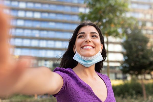 Mulher sonriente com máscara facial