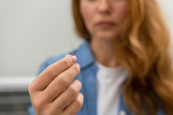 Mulher recebendo tratamento para queda de cabelo em uma clínica - Tricotilomania: o que é e como se cura?