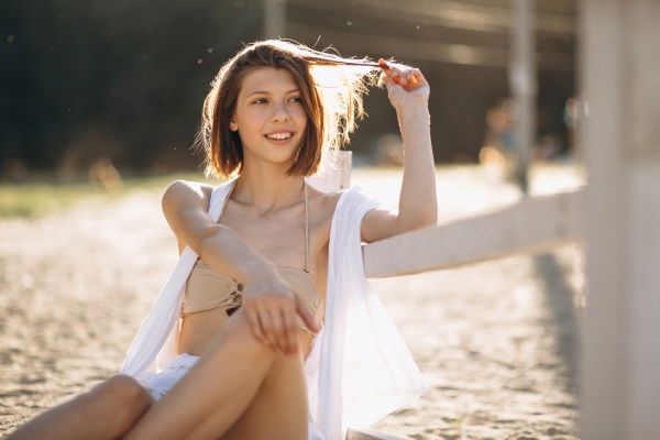Mulher feliz na praia - verão e calvície