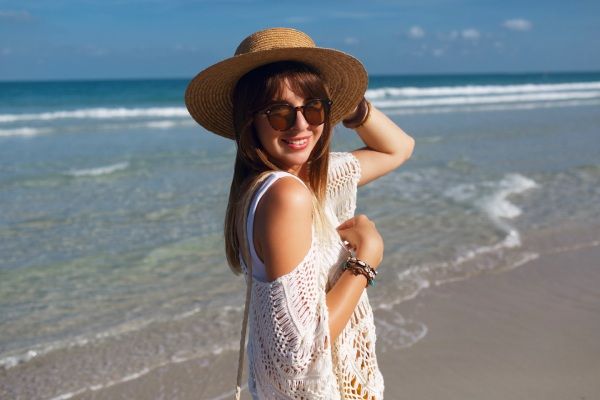 verão e calvície - Mulher feliz passeando pela praia