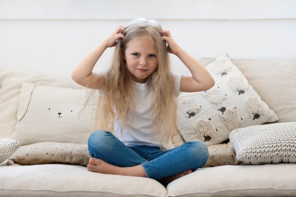 Garotinha toca sua cabeça com síndrome do cabelo impenteável