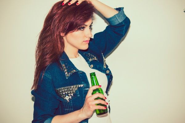 Mulher moderna com cerveja e pose legal
