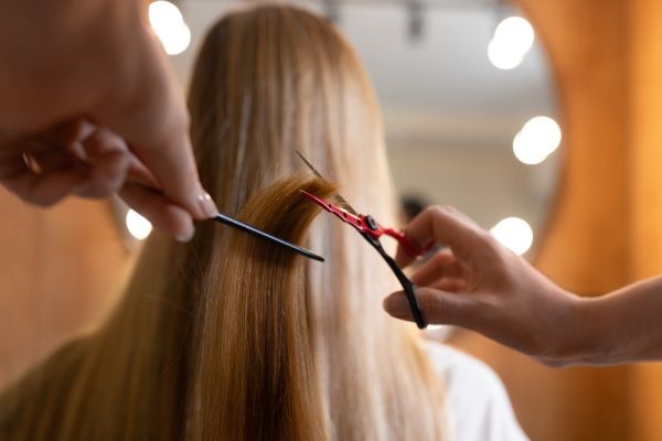 Uma cliente a cortar o cabelo no cabeleireiro