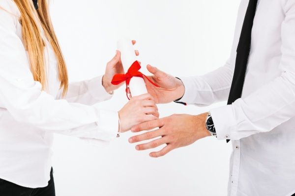 Mãos de pessoas com diploma