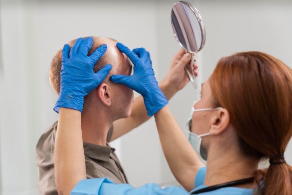 Dermatologista realiza testes a homem com alopecia