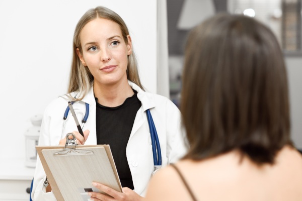 Médico do sexo feminino que explica o diagnóstico para a paciente jovem com hipertricose 