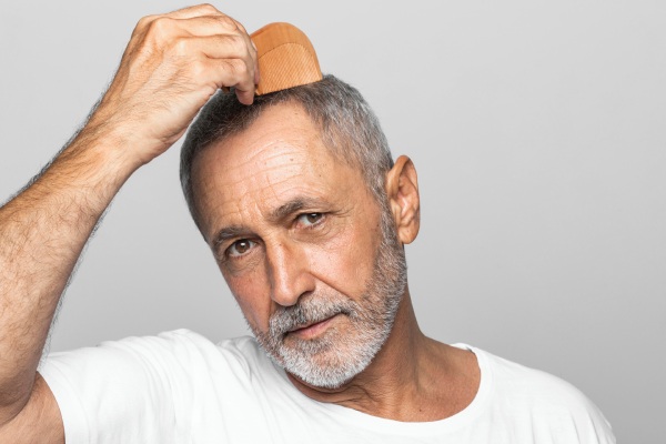 Homem mais velho penteando o cabelo