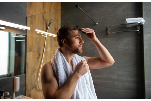 Homem no banheiro arrumando o cabelo