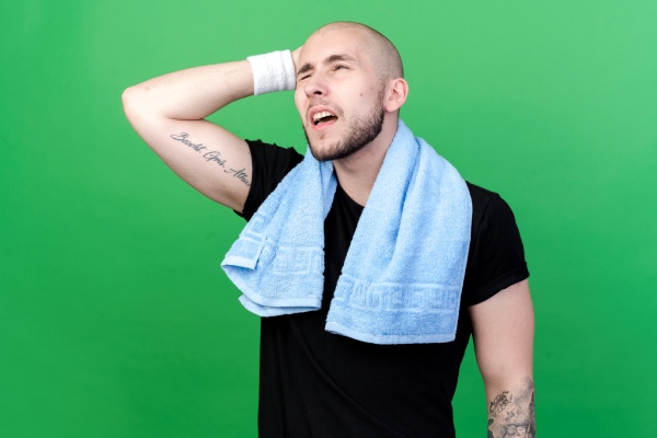 Transplante capilar no verão - Homem com cabelo emergindo após um implante capilar com um rosto cansado