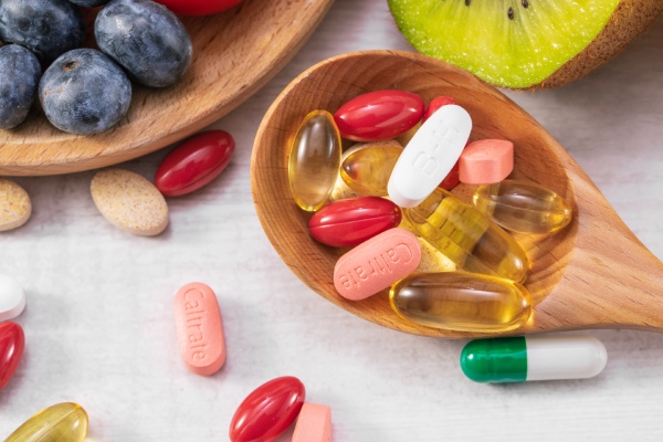 suplementos alimentares em forma de pílula ao lado de alimentos saudáveis