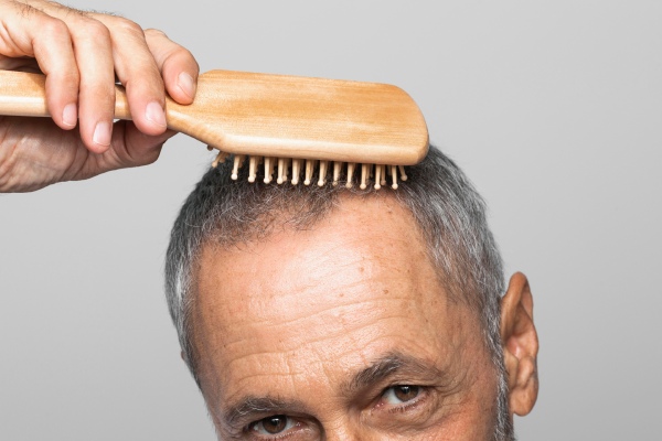 afinamento dos cabelos - Idoso penteando seu cabelo fino