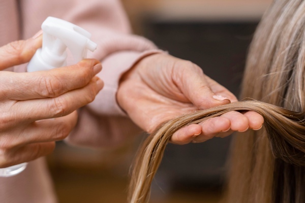 Um cabeleireiro analisa o cabelo de uma mulher com hipotireoidismo de Hashimoto