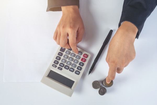 Homem faz contas com uma calculadora