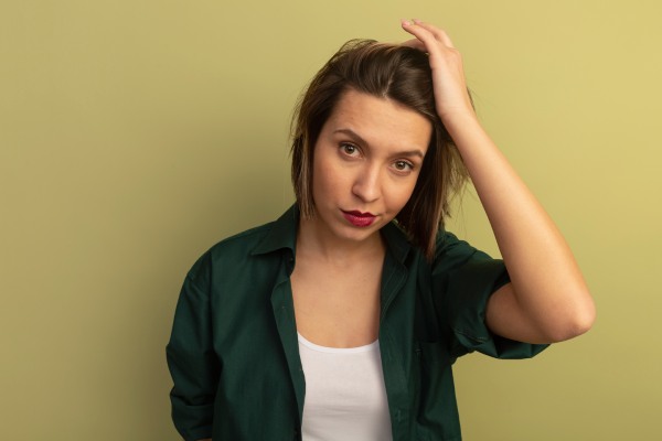 menina com queda de cabelo acaricia-o suavemente
