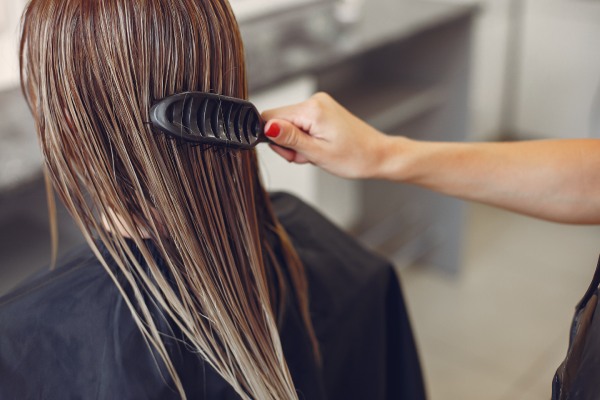 Mulher secando o cabelo em um salão de cabeleireiro